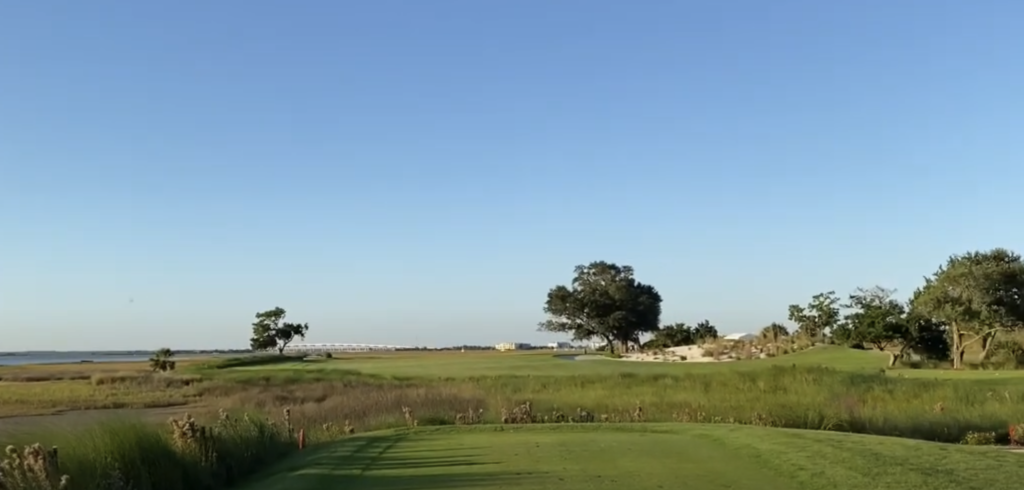 Coastal golf course with clear blue sky.